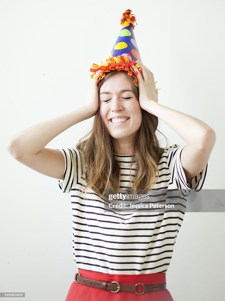 Studio shot of young woman wearing party hat