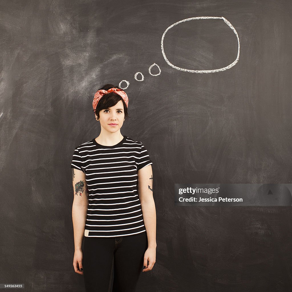 Portrait of young woman in front of blackboard