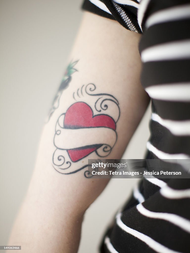 Heart shaped tattoo on woman's arm