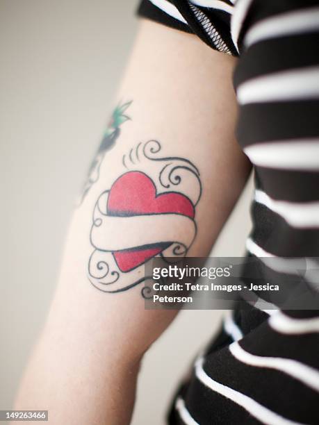 heart shaped tattoo on woman's arm - tattoo stock pictures, royalty-free photos & images