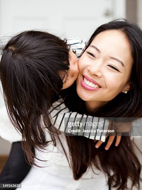 usa, utah, salt lake city, smiling woman kissing by her daughter (4-5) - asian mom kid kiss bildbanksfoton och bilder
