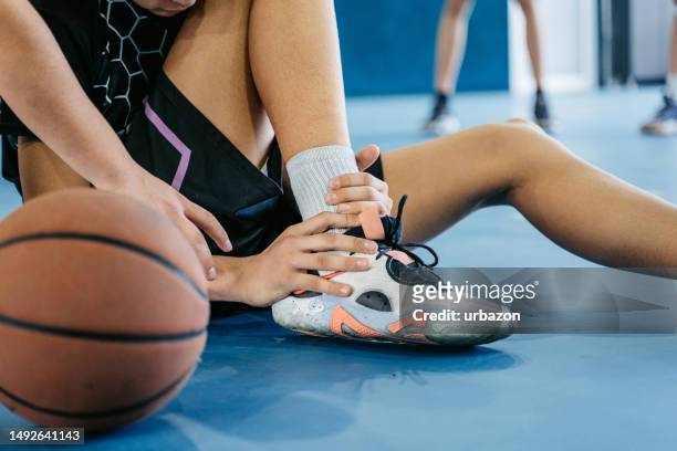teenage boy injuring his ankle while playing basketball indoors - swollen ankles 個照片及圖片檔