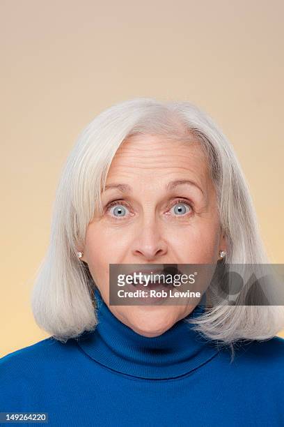 studio shot of surprised senior woman - senior woman studio stock pictures, royalty-free photos & images