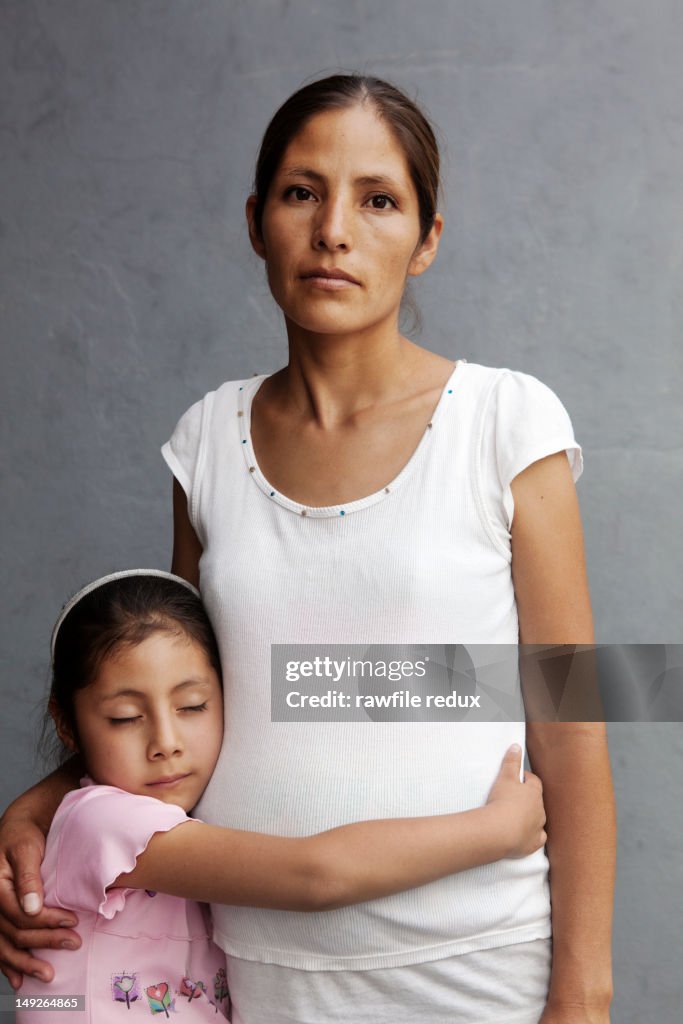 Mexican mother and daughter hugging.