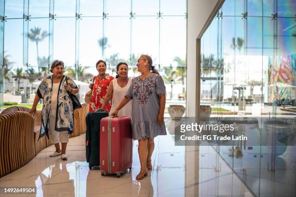 amigo mayor llegando a un hotel con su equipaje - mature latin women fotografías e imágenes de stock
