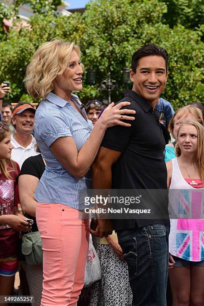 Katee Sackoff attempts to place handcuffs on Mario Lopez at "Extra" at The Grove on July 25, 2012 in Los Angeles, California.