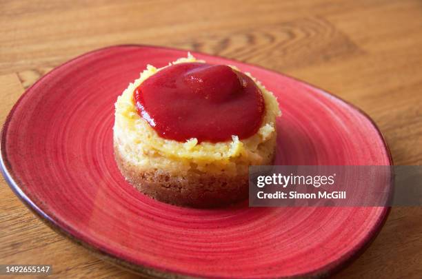 small baked cheesecake with guava coulis on a dessert plate - guave stockfoto's en -beelden