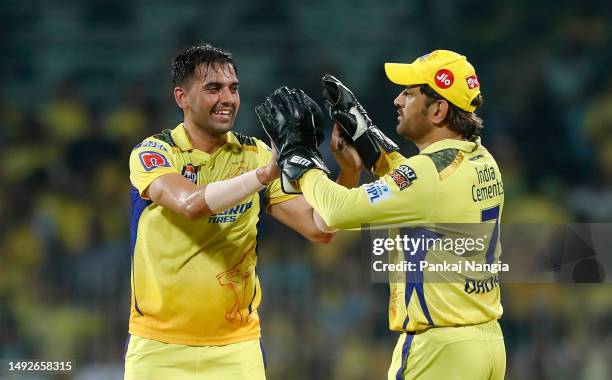 Deepak Chahar of Chennai Super Kings celebrates taking the wicket of Wriddhiman Saha of Gujarat Titans with teammate Mahendra Singh Dhoni during the...