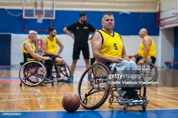 older paraplegic sportsman in wheelchair looking at camera - wheelchair basketball team stock pictures, royalty-free photos & images