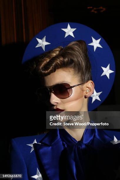 Backstage at the Gareth Pugh show, a model wears a royal blue star spangled jacket with padded shoulders and a matching halo style hat, during London...