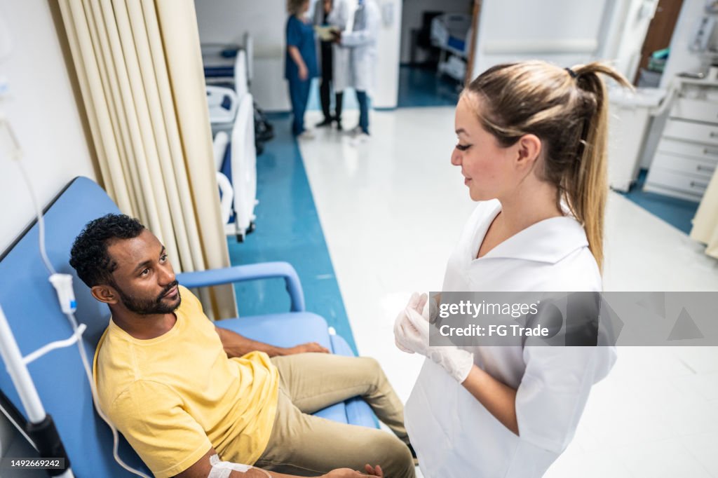 Nurse talking to patient with IV drip in the hospital