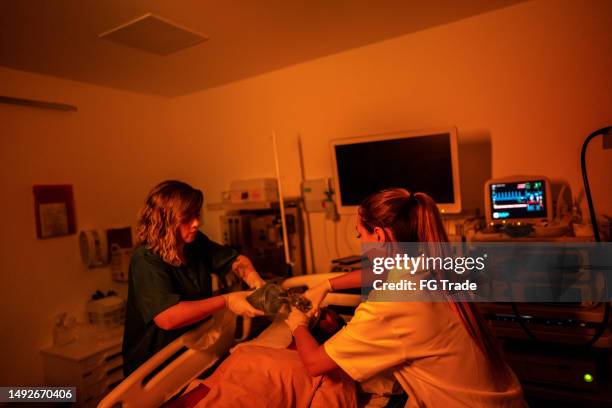 doctor using manual ventilator in the patient in the hospital - hospital ventilator stock pictures, royalty-free photos & images