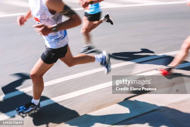 low section amateur people running fast in the city, blurred motion sports background - marathon stockfoto's en -beelden