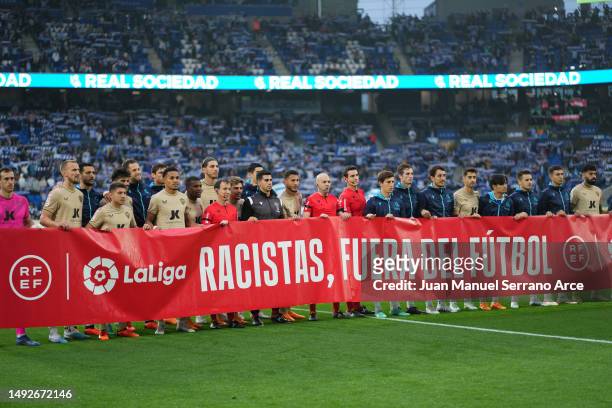 Players of both teams and match officials pose for a photo with a banner against racism prior to the LaLiga Santander match between Real Sociedad and...