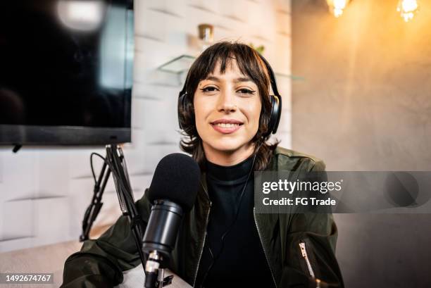 porträt einer jungen frau während eines podcasts - moderator stock-fotos und bilder