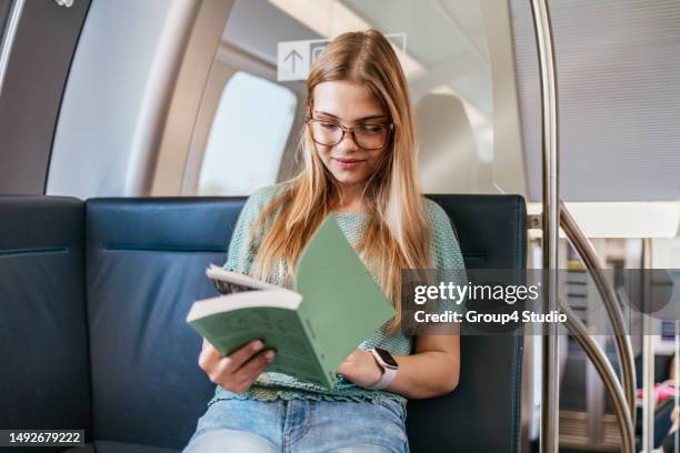 adolescente assise dans un train rapide - woman sitting train station photos et images de collection