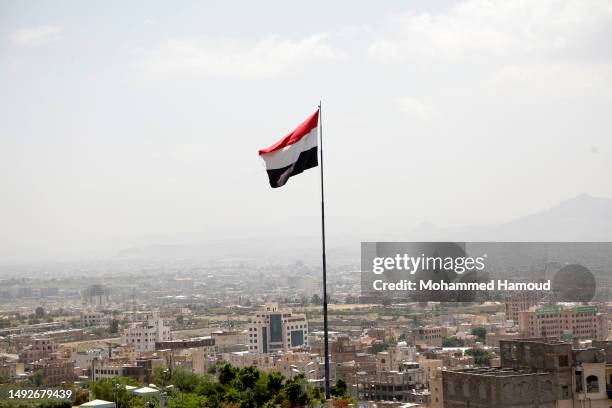 The flag of Yemen established on a mountain overlooking Sana'a city on the day marking the North-South Unification 33-anniversary on May 22, 2023 in...
