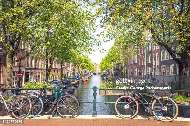 bicycles on a bridge in amsterdam, holland - amsterdam spring stock pictures, royalty-free photos & images