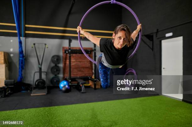 woman doing exercises with aerial hoop in gym - lyra stock pictures, royalty-free photos & images