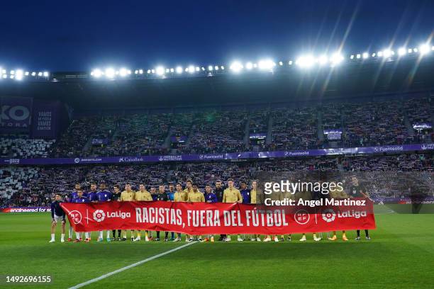 Players of both teams and match officials pose for a photo holding a banner against racism prior to the LaLiga Santander match between Real...