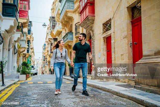 young couple enjoying a walk in valletta, malta - malta city stock pictures, royalty-free photos & images
