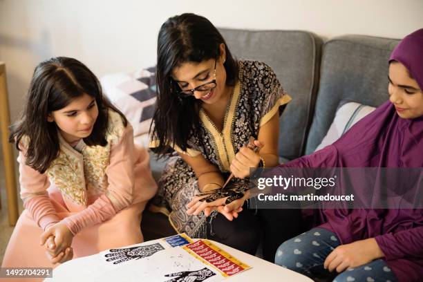 north-american muslim woman drawing with henna at ramadan. - tatuagem de henna imagens e fotografias de stock