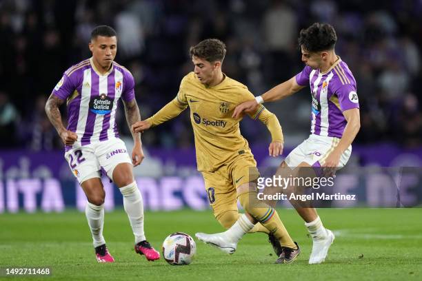 Gavi of FC Barcelona is challenged by Darwin Machis and Alvaro Aguado of Real Valladolid CF during the LaLiga Santander match between Real Valladolid...