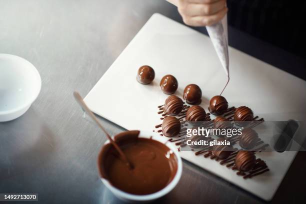 schokoladentrüffel dekorieren. - chocolate factory stock-fotos und bilder
