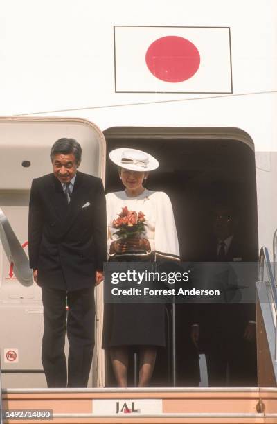 View of married couple, Japanese Emperor Hirohito and Empress Kojun as they bow after stepping out of their plane during a Royal Visit, Beijing,...