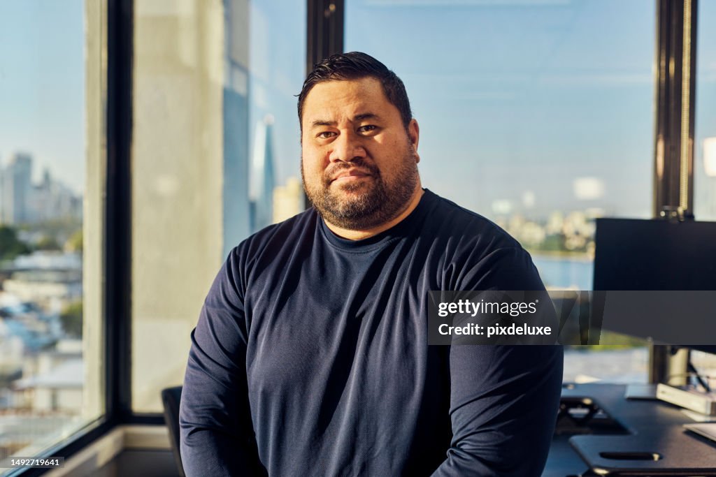 Geschäftsmann aus dem pazifischen Inselstaat, der in einem australischen Büro mit Blick auf den Hafen von Sydney und die Stadt arbeitet.