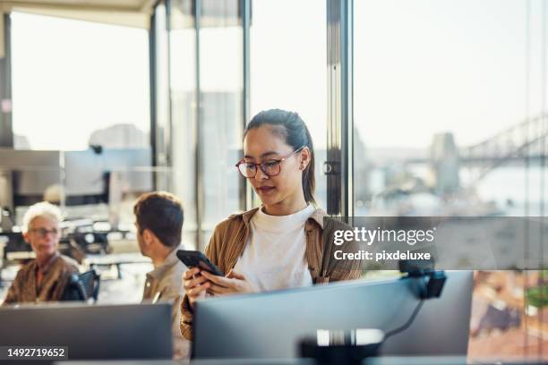 young asian australian businesswoman working on tech in an australian office. - aussie stock pictures, royalty-free photos & images