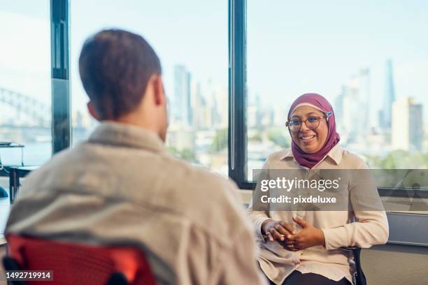 indonesian-australian woman talking in a one-to-one session in the workplace. - australia net session stock pictures, royalty-free photos & images