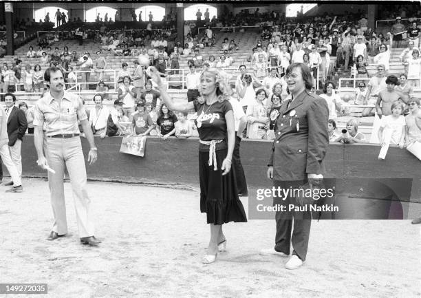 Watched by American disc jockey Steve Dahl , model Lorelei Shark throws out a baseball during an anti-disco promotion at Comiskey Park, Chicago,...