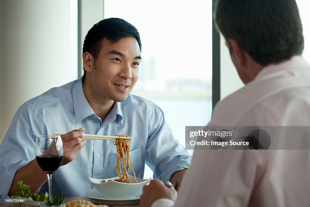 Businessman eating noodles