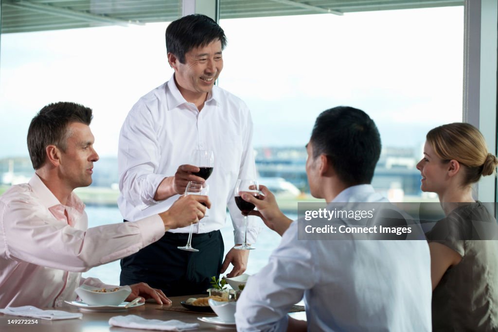 Multi racial businesspeople toasting wine
