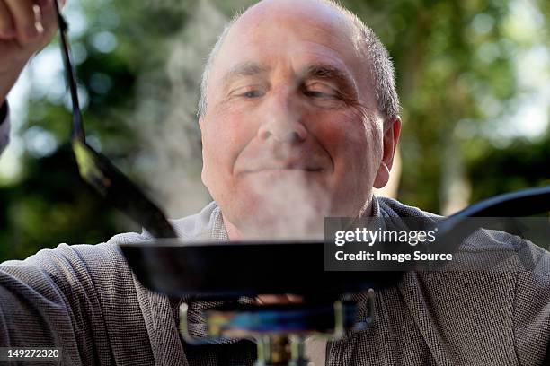 senior man cooking on camping stove - smelling food stock pictures, royalty-free photos & images