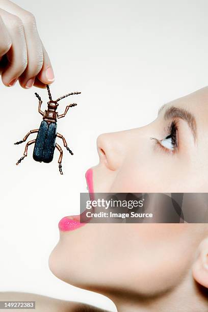 young woman eating plastic beetle - geöffneter mund stock-fotos und bilder