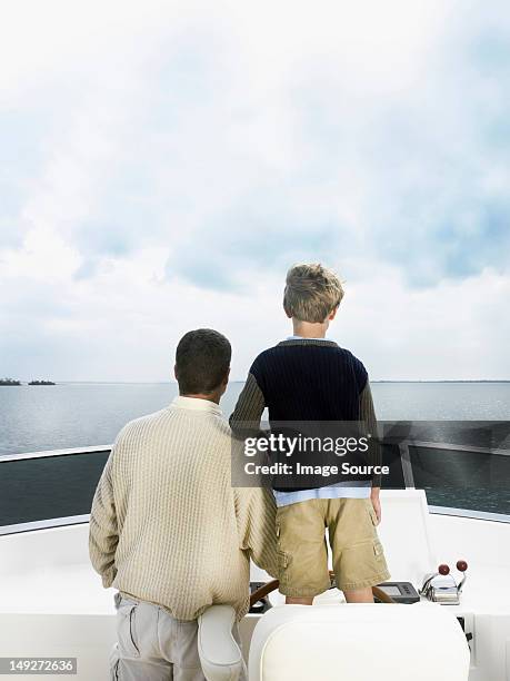 father and son on boat - father son sailing stock-fotos und bilder