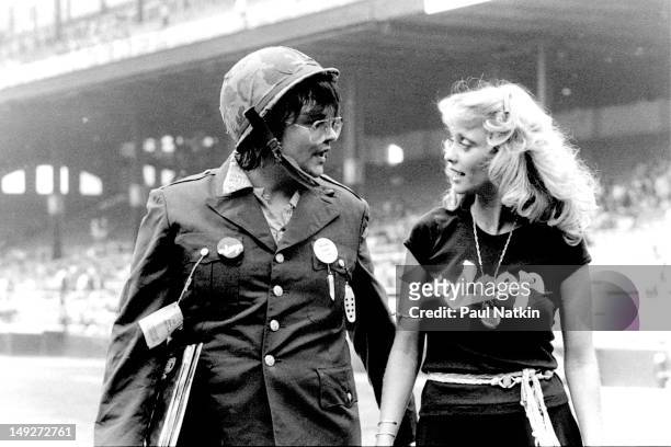 American disc jockey Steve Dahl and model Lorelei Shark walk on the field together during an anti-disco promotion at Comiskey Park, Chicago,...