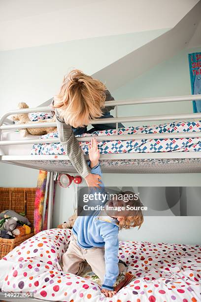 young boys playfighting on their bunk bed - litera fotografías e imágenes de stock