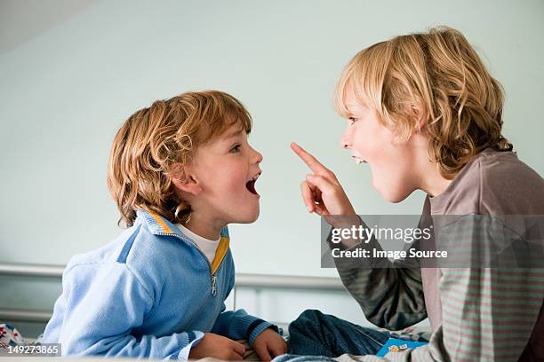 two young boys quarrelling - two kids looking at each other stockfoto's en -beelden
