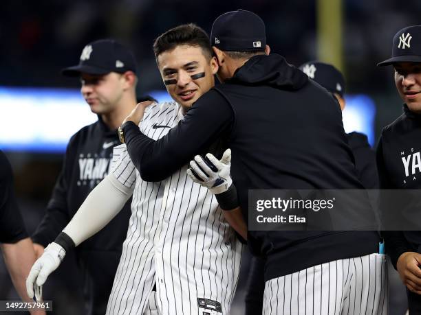 Anthony Volpe of the New York Yankees is congratulated by manager Aaron Boone after Volpe drove in the game winning run with a sacrifice fly against...