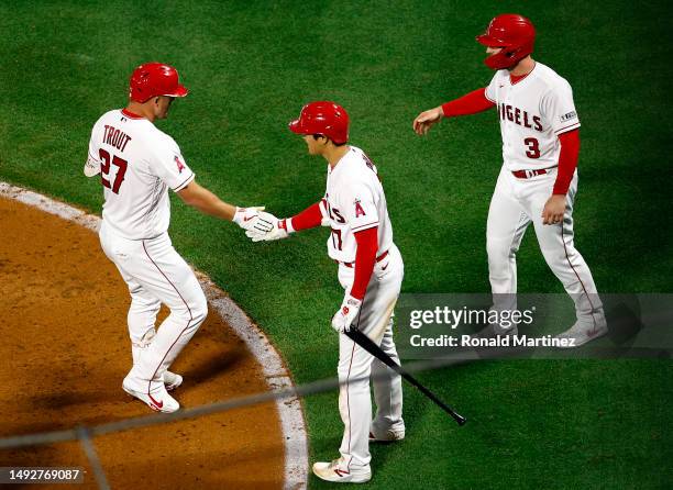 Mike Trout celebrates a home run with Shohei Ohtani and Taylor Ward of the Los Angeles Angels against the Boston Red Sox in the eighth inning at...