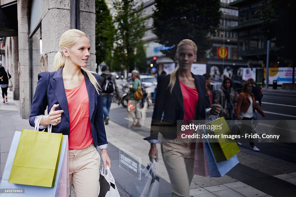 Woman with shopping bags window shopping