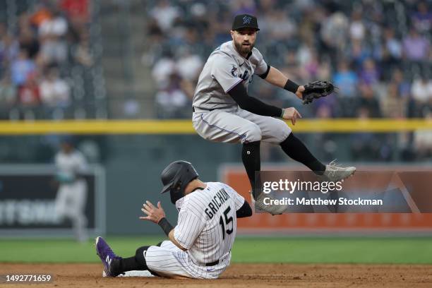 Jon Berti of the Miami Marlins throws to first base over Randal Grichuk of the Colorado Rockies in the fifth inning at Coors Field on May 23, 2023 in...