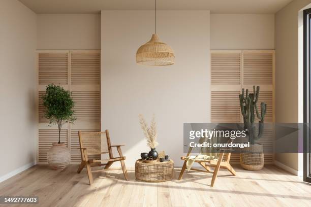 interior de la sala de estar con sillones de mimbre, plantas en macetas y mesa de café - estilo boho fotografías e imágenes de stock