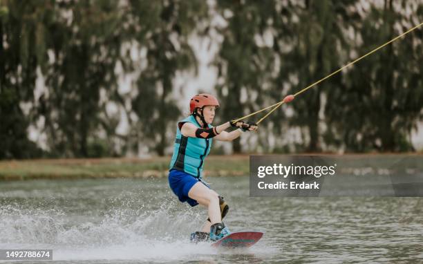 erstaunliche erwachsene wakeboarderin. - wasserski stock-fotos und bilder