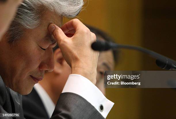 Koji Nagai, incoming president and chief executive officer of Nomura Holdings Inc., left, pauses during a news conference in Tokyo, Japan, on...