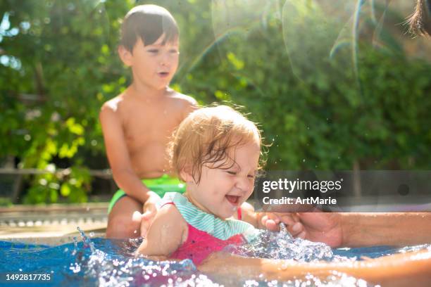 bambino e ragazza che si divertono in una piscina durante le vacanze estive - fratello foto e immagini stock