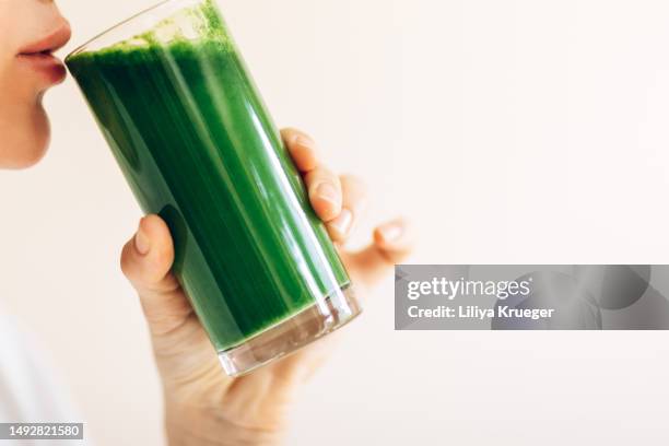 close-up of woman drinking green vegetable juice. - smoothie close up textfreiraum stock-fotos und bilder